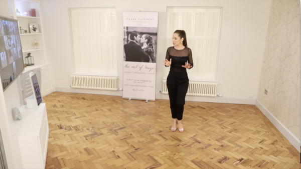 Kim explaining in a tango technique class