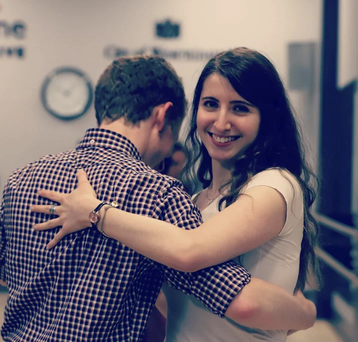 two tango students laughing as they learn