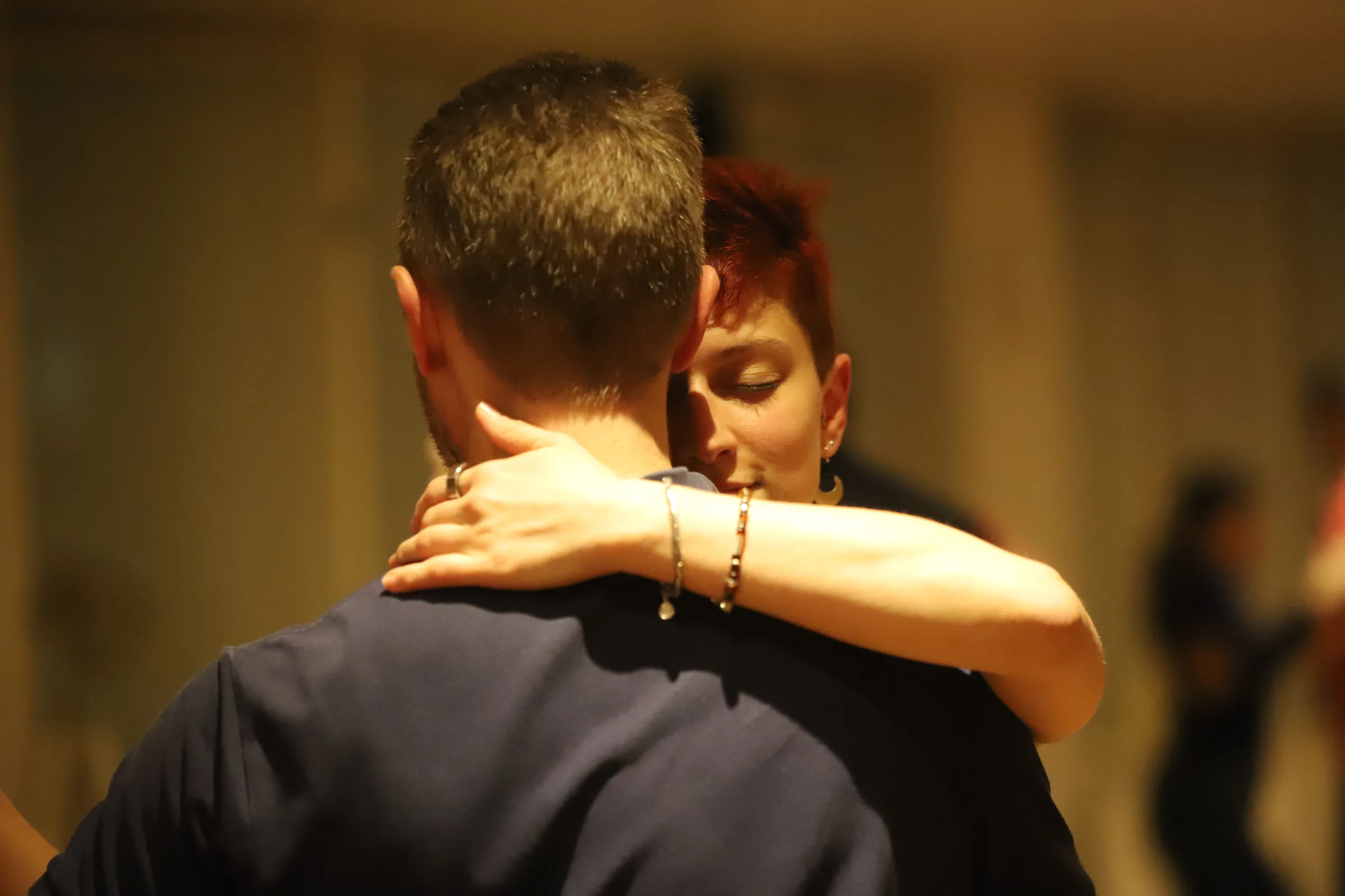tango couple dancing in dark room illuminated by a soft light