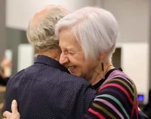 two students laughing and hugging