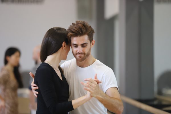 student smiling at the camera as he dances tango